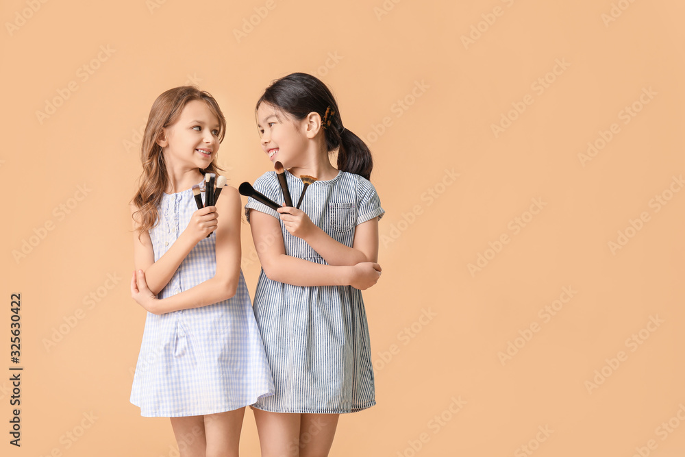 Cute little makeup artists on color background