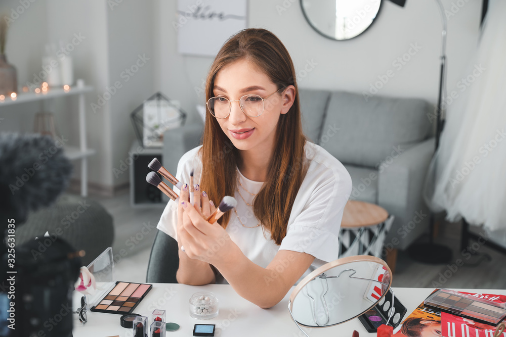 Young beauty blogger recording video at home