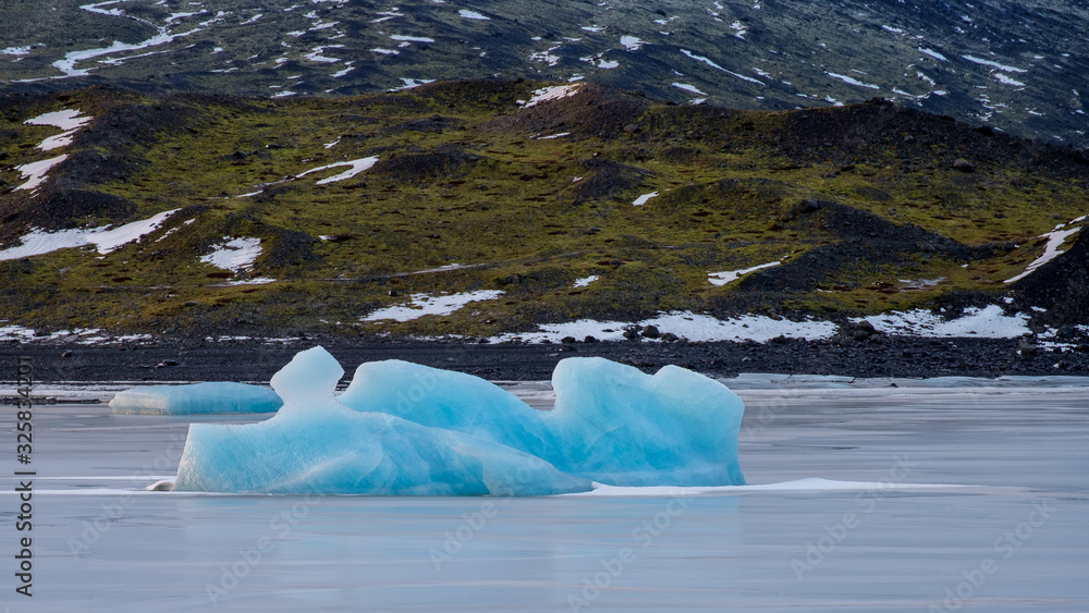 Iceland: blue iceberg in the middle of a frozen lake