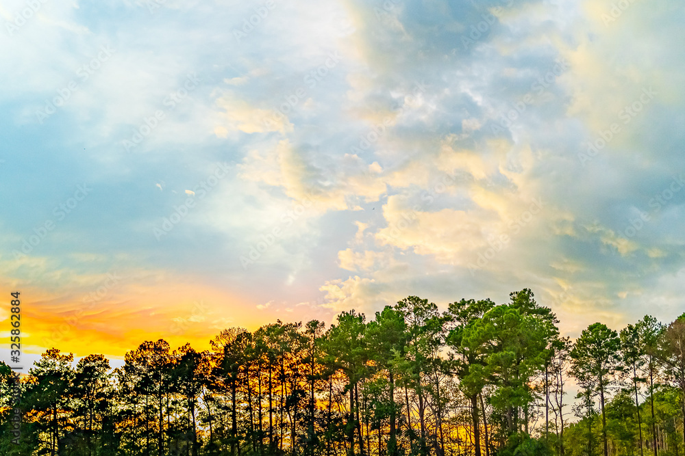 White, orange, blue and dark clouds on sky on the sunset summer background Georgia, US