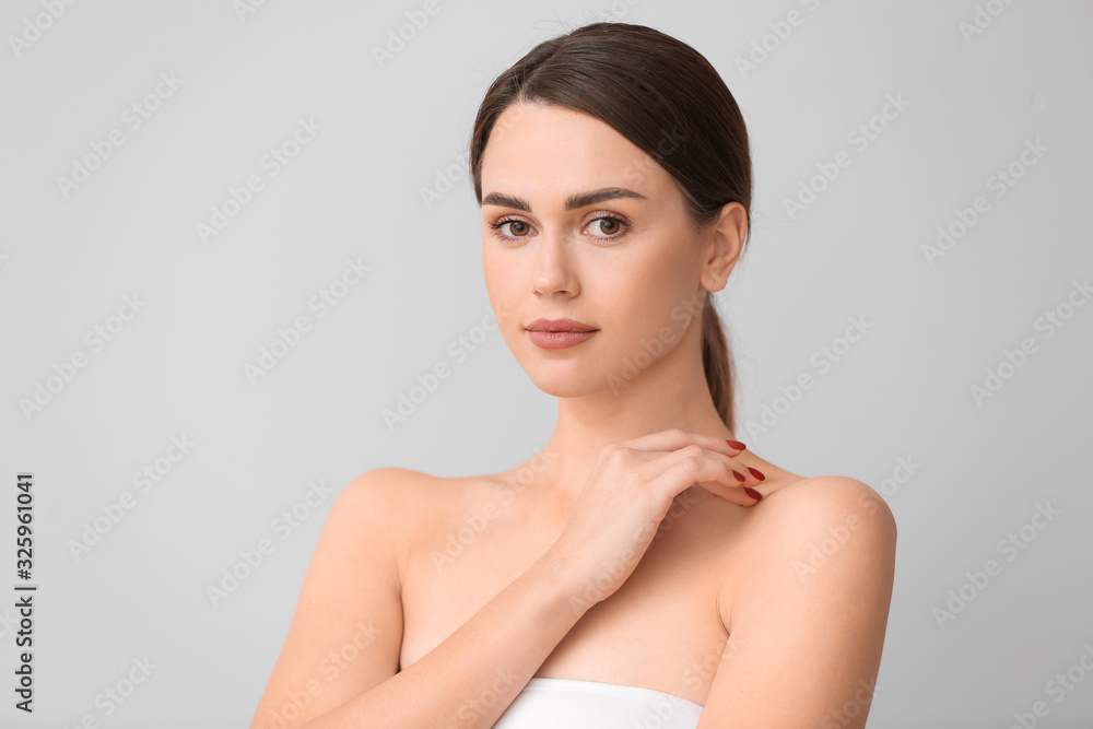 Beautiful young woman on light background. Plastic surgery concept