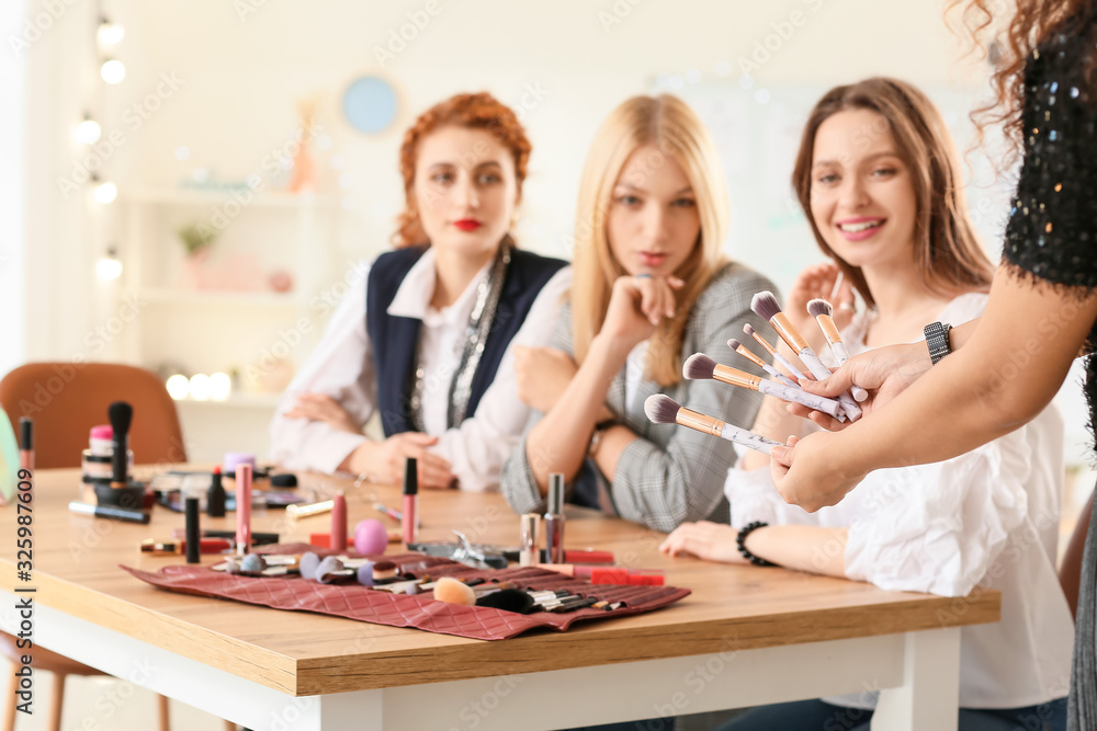 Young woman teaching students in makeup school