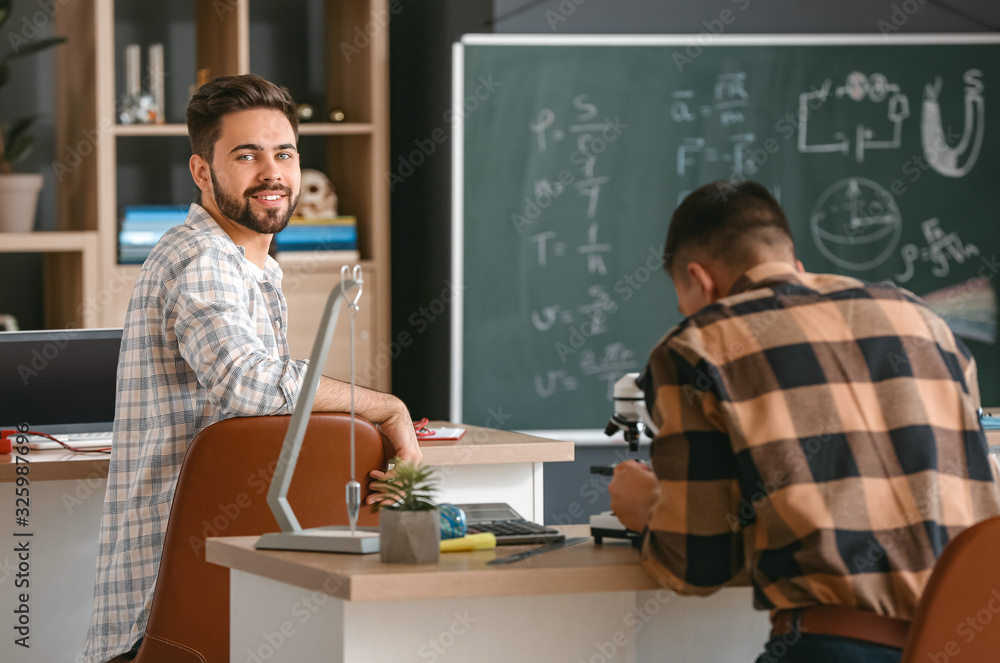 Young man at physics lesson in classroom