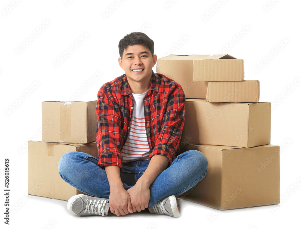 Asian man with moving boxes on white background