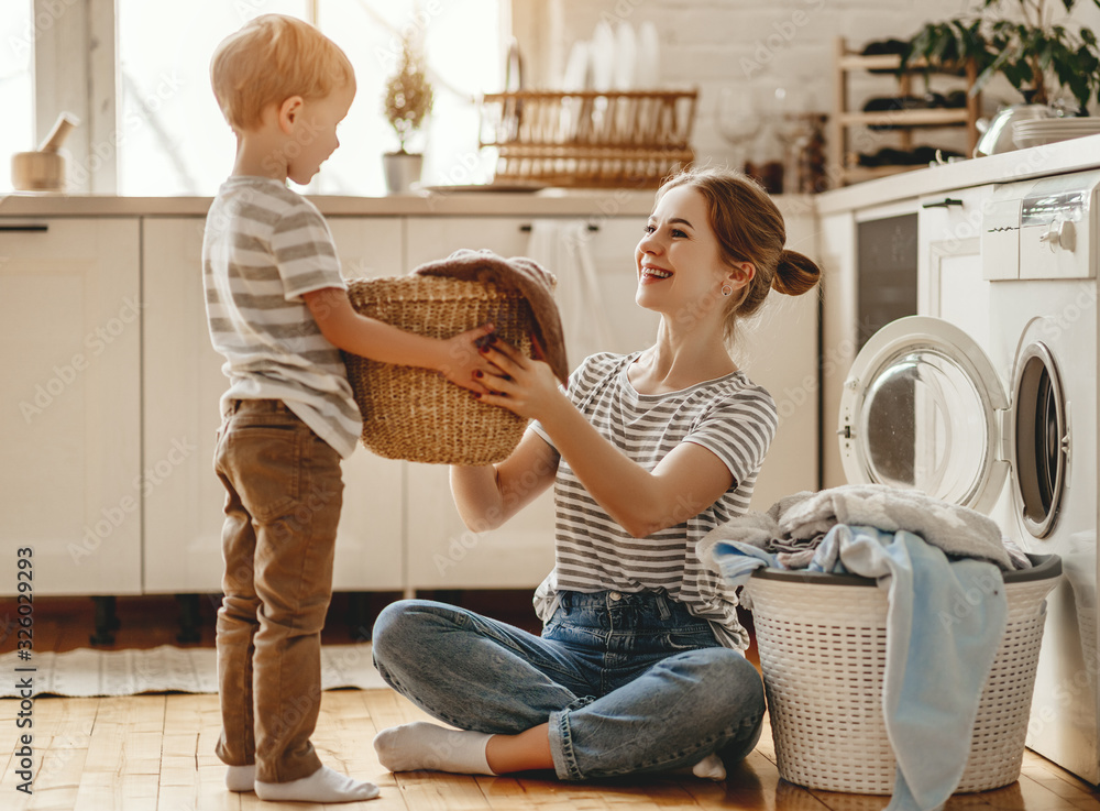 happy family mother housewife and child   in laundry with washing machine .