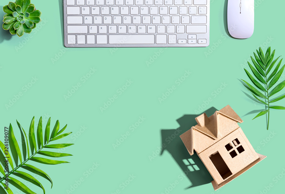 Cardboard house with computer keyboard - flat lay