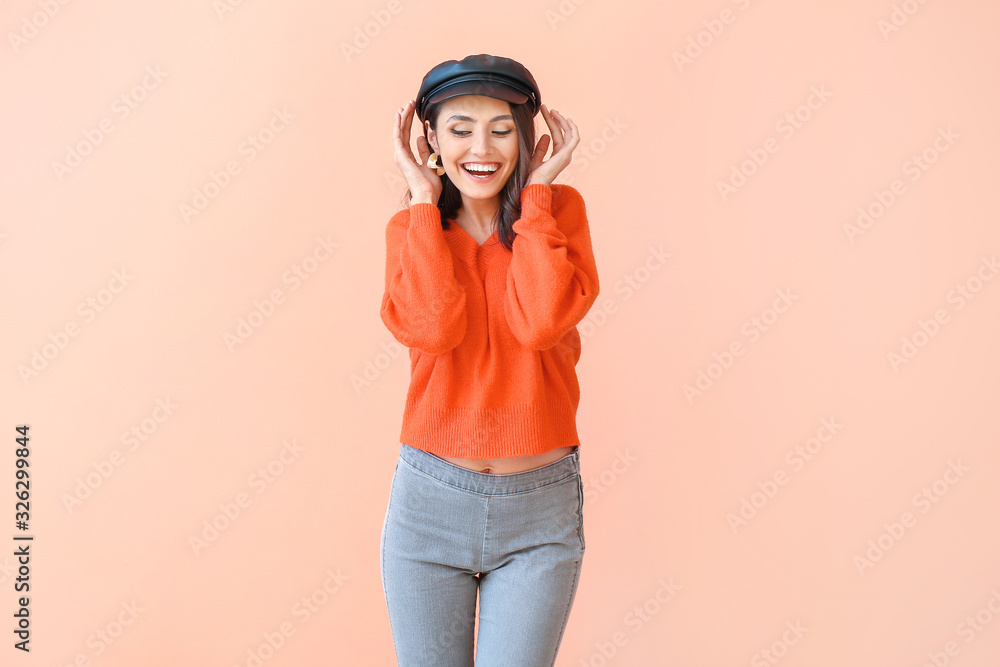 Beautiful young woman in warm sweater on color background