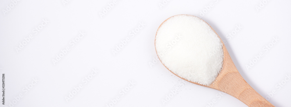 Brown sugar in a wooden spoon on a white background, healthy sugar. Used for cooking or desserts.