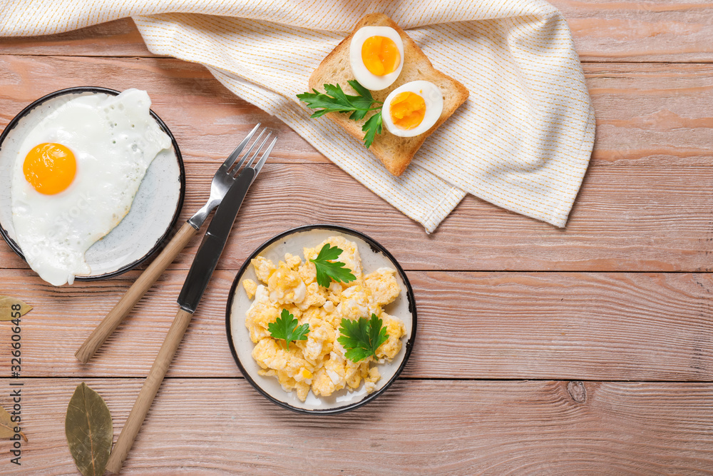 Different tasty dishes with eggs on wooden table