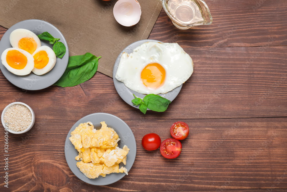 Different tasty dishes with eggs on wooden table