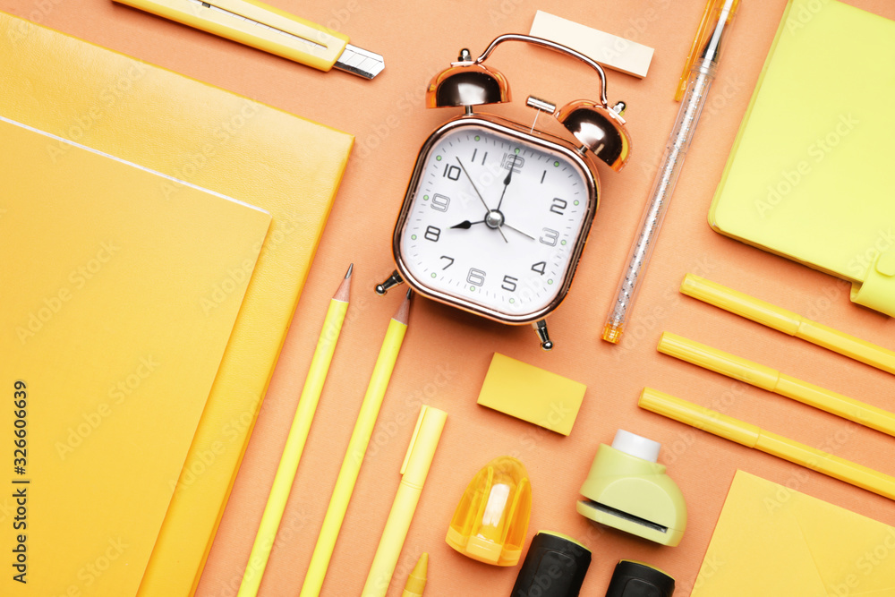 Set of school supplies with clock on color background