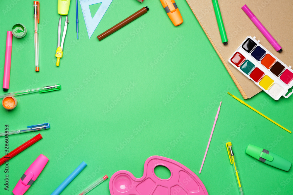 Frame made of school supplies on color background