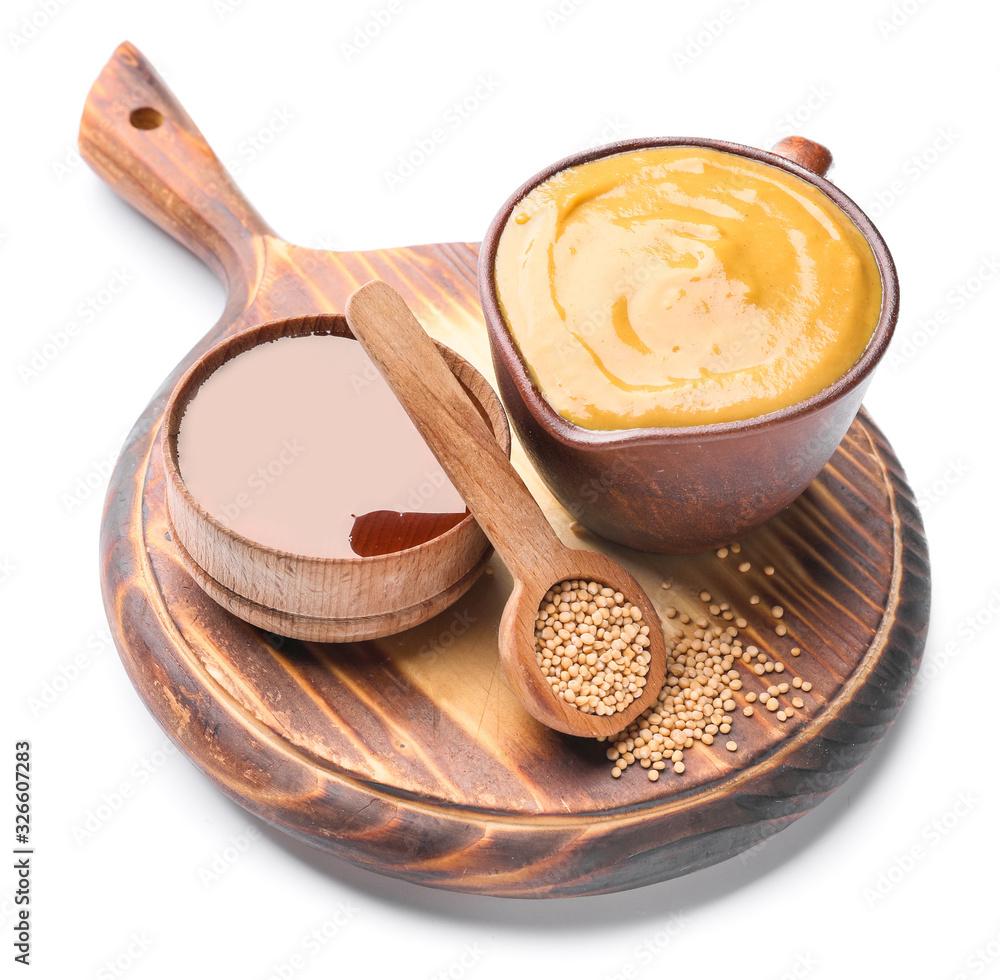 Jug of tasty honey mustard sauce with ingredients on white background