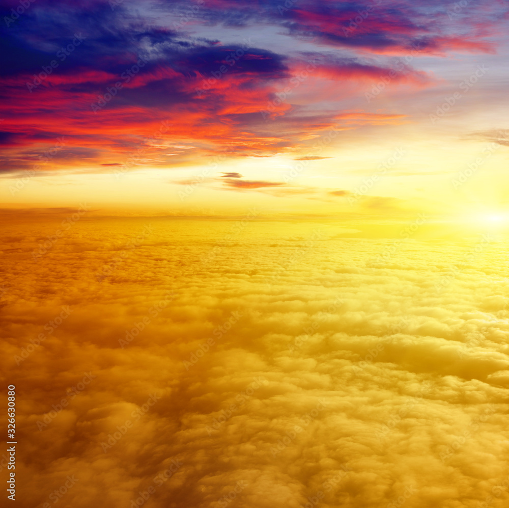 Sunrise above clouds from airplane