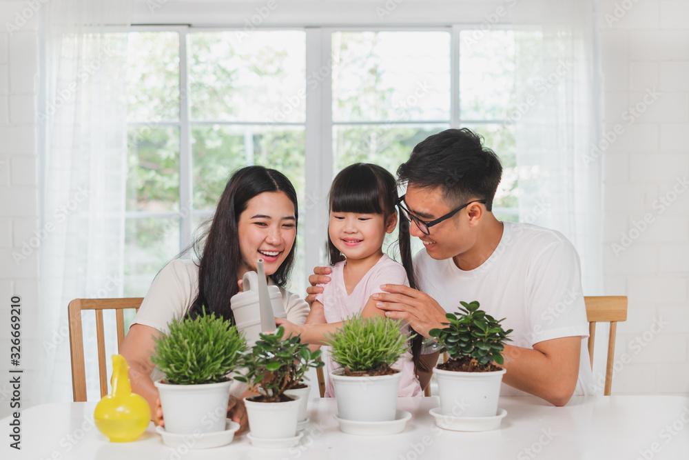 亚洲可爱女孩帮助父亲和母亲种花，在家浇水，亚洲家庭花园