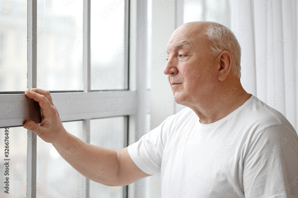 Portrait of elderly man near window