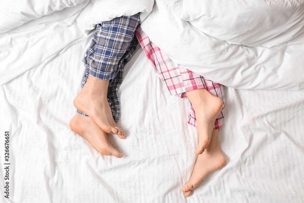 Young couple lying in bed, top view