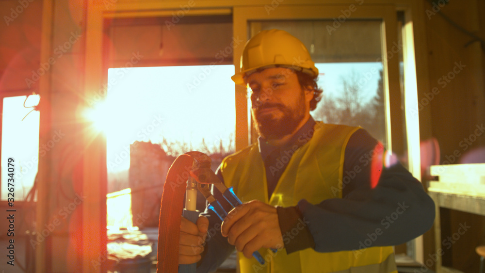 CLOSE UP: Experienced plumber tightens up a fitting onto a hose with a spanner.