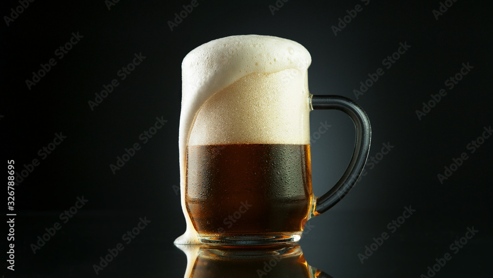 Beer foam overflowing from glass pint