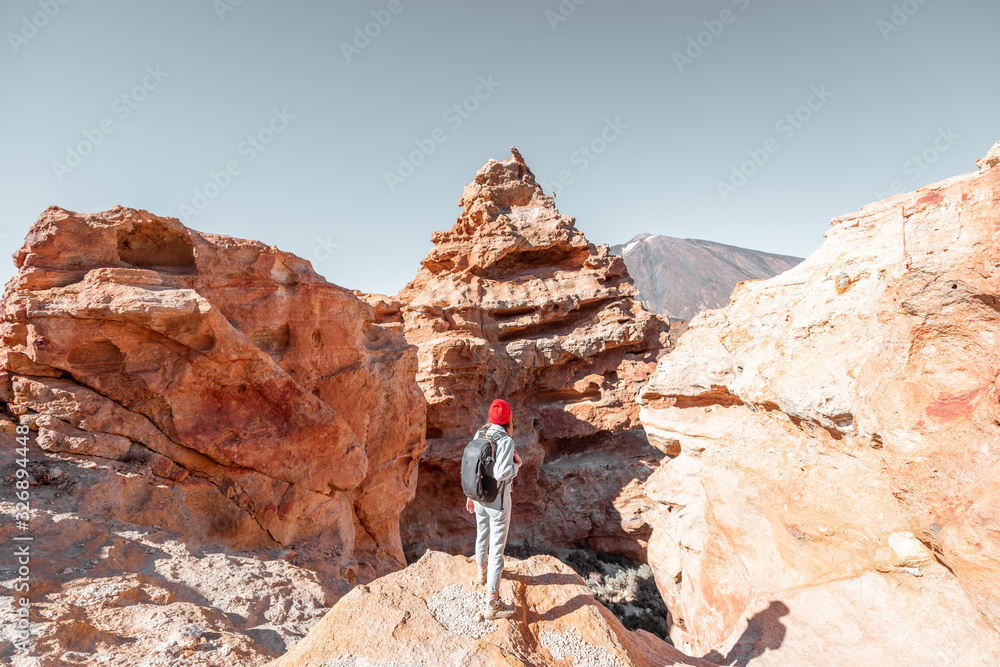 女性旅行者站在火山起源的巨石之间欣赏美丽的风景