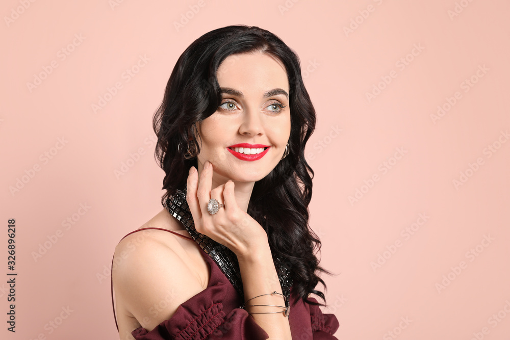 Young woman with beautiful jewelry on color background