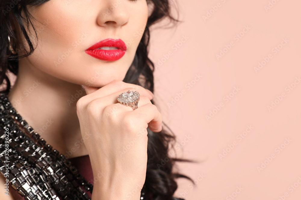 Young woman with beautiful jewelry on color background, closeup