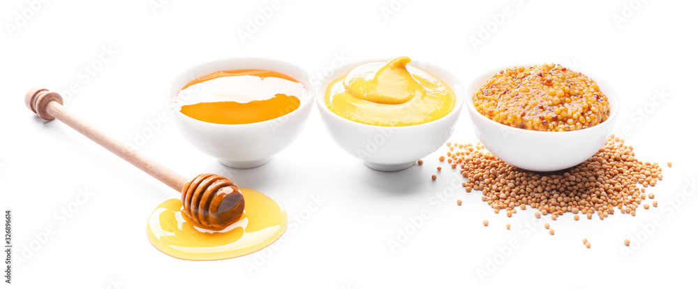 Bowls of honey, mustard and sauce on white background