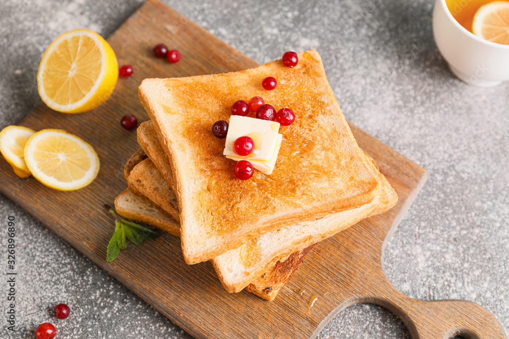 Tasty toasted bread with honey, butter and berries on grey background