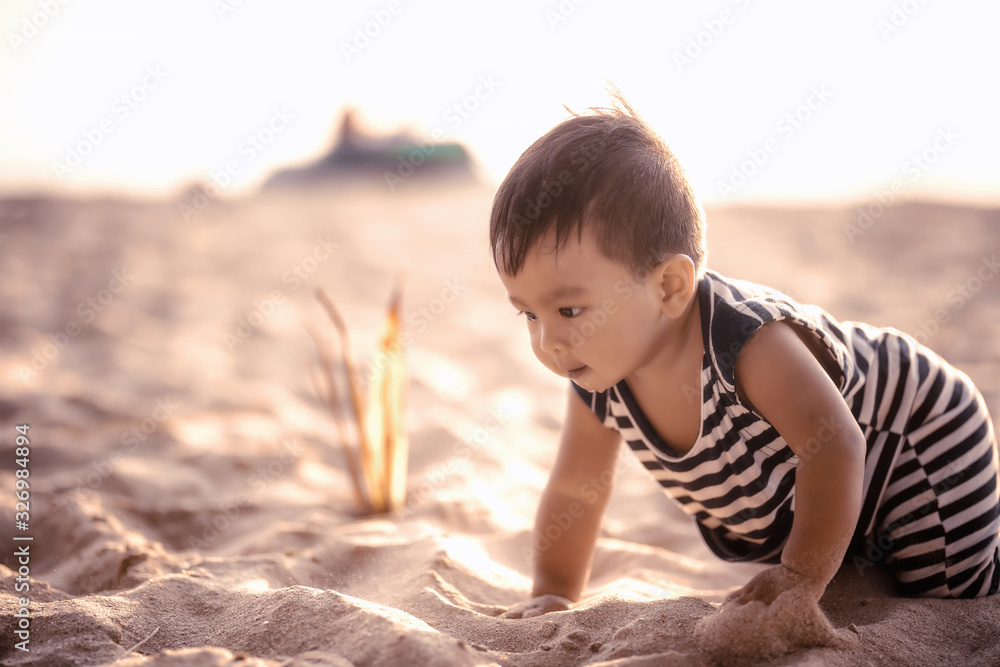 Soft focus and background blur concept The boy is playing in the sand on the beach, happy holiday.