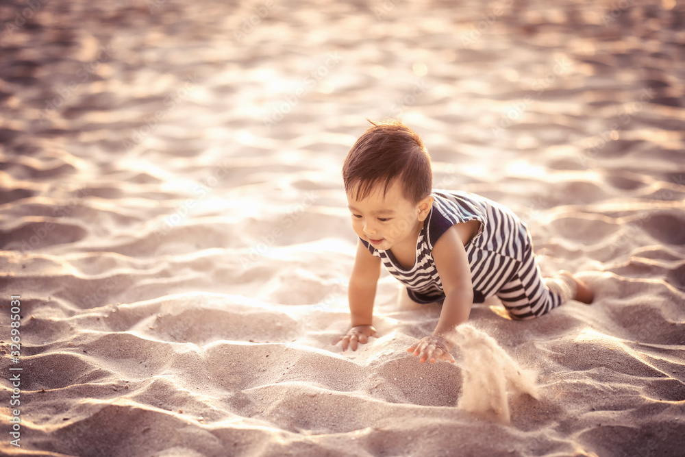 Soft focus concept The boy is playing in the sand on the beach, happy holiday.