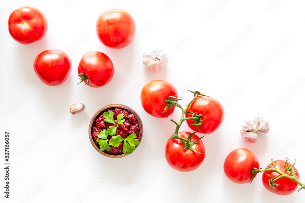 Tomato frame with suase and garlic on white background top-down