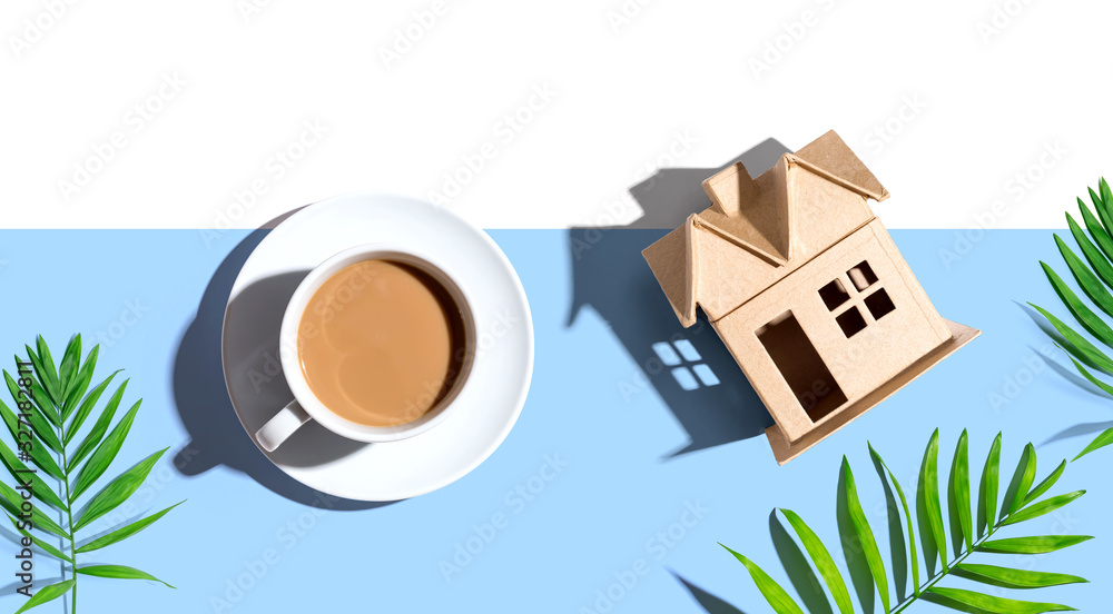 Cardboard house with a cup of coffee - flat lay