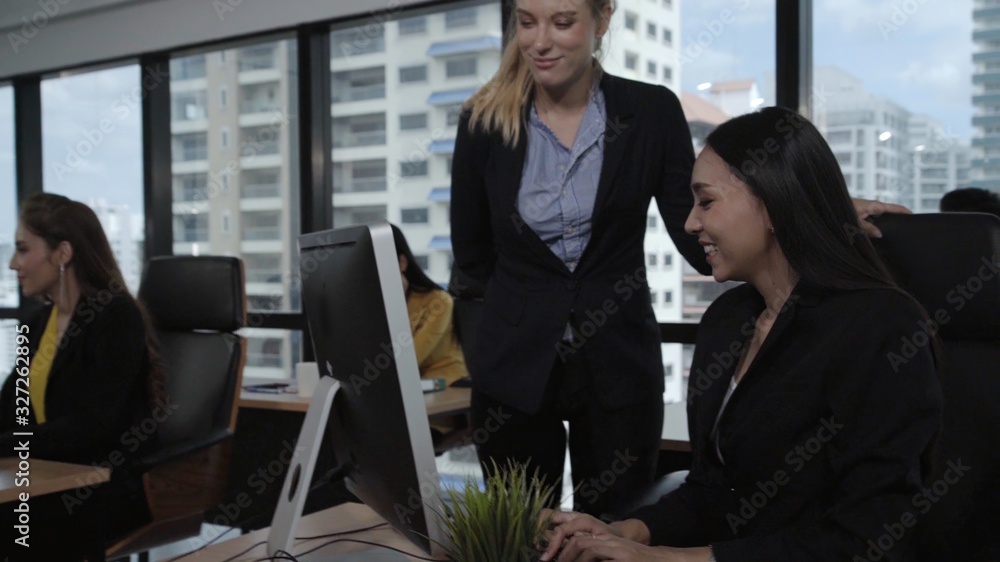 Young leader gives advice to young woman worker in modern office. Leadership and training concept.