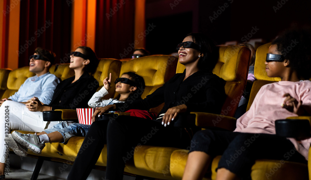 Group of people watch movie with 3D glasses in cinema theater with interest looking at the screen, e