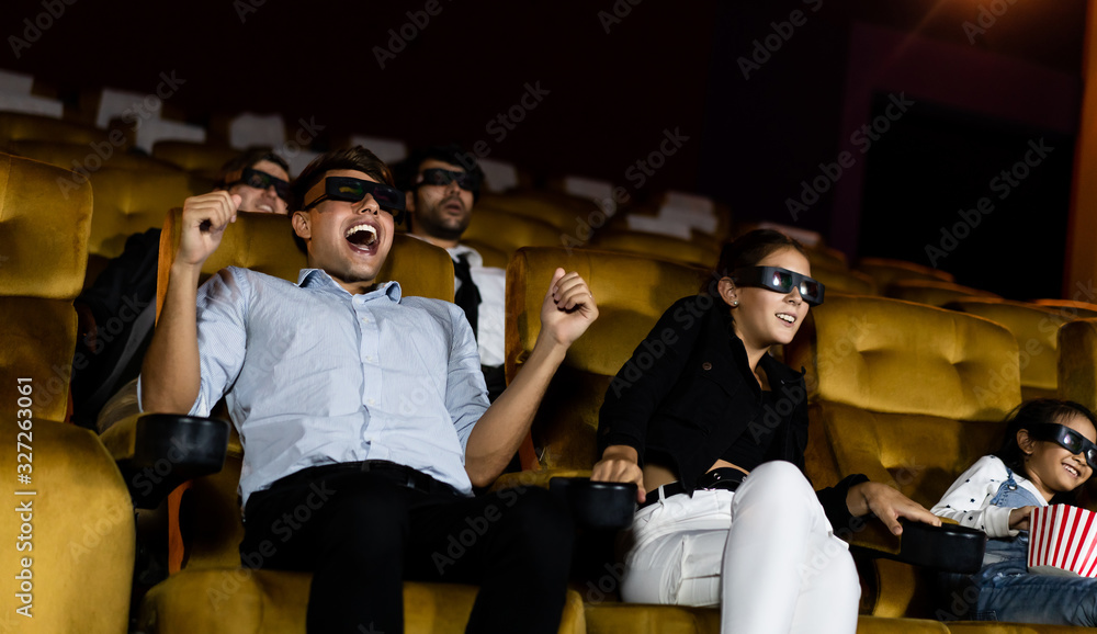 Group of people watch movie with 3D glasses in cinema theater with interest looking at the screen, e