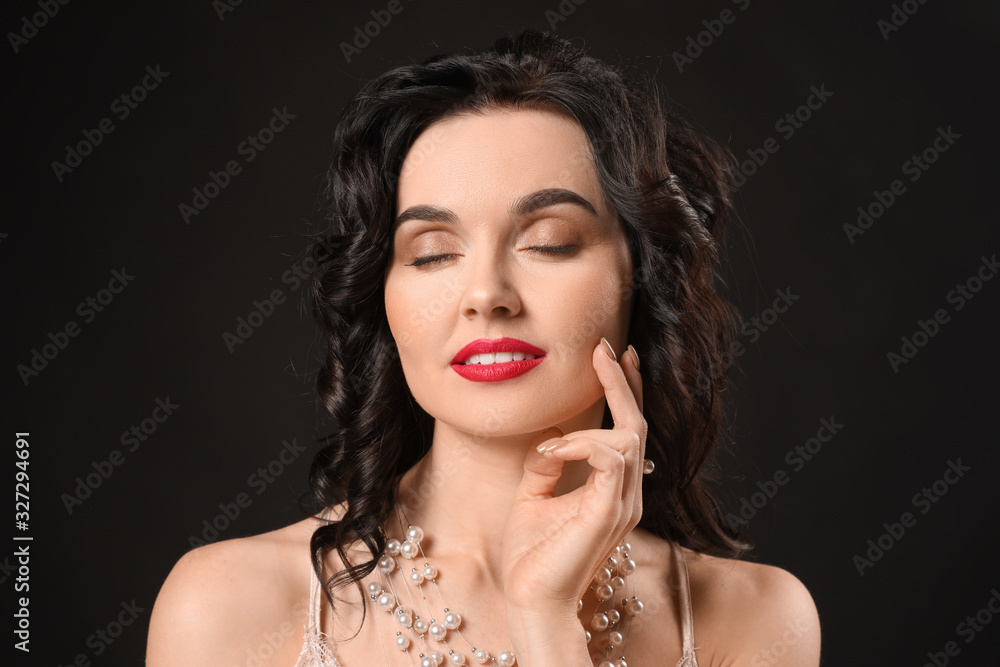 Young woman with beautiful jewelry on dark background