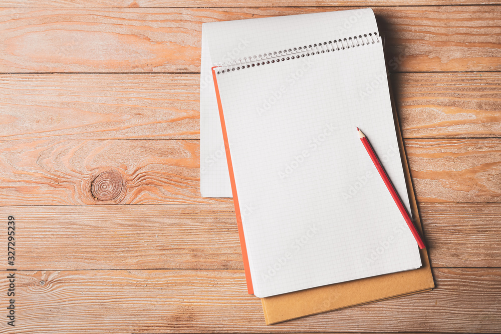 Notebook and pencil on wooden table