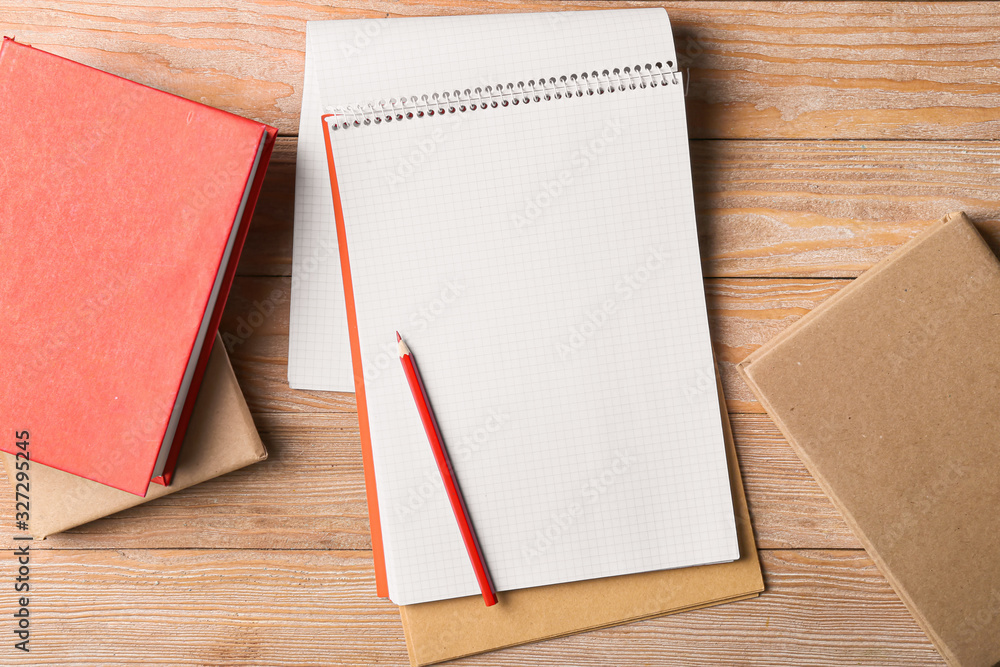 Notebooks and pencil on wooden table