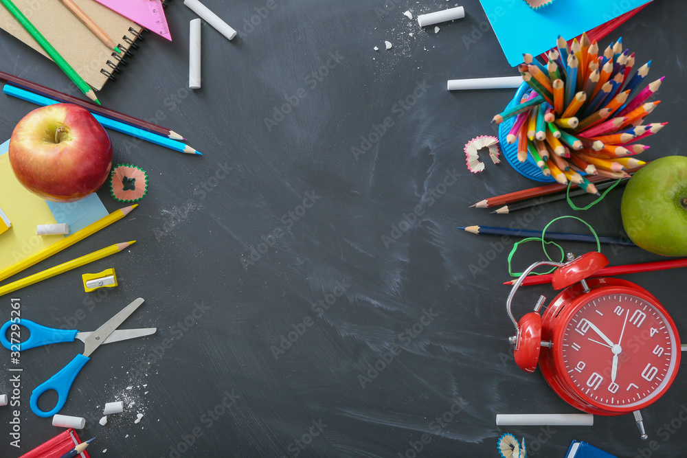 Set of school stationery on blackboard