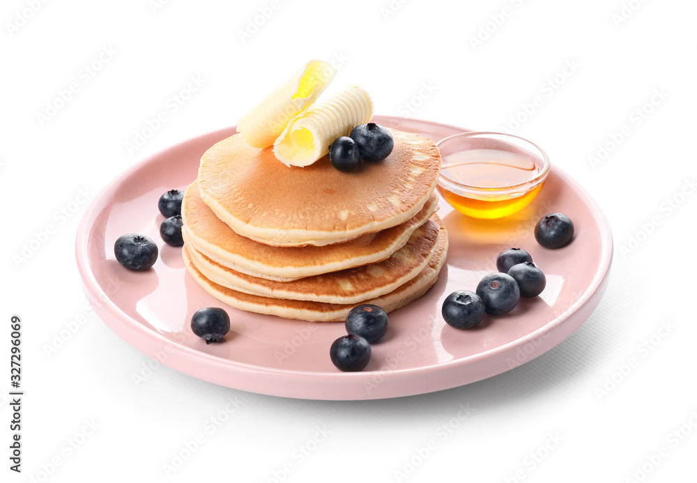 Tasty pancakes with honey, butter and berries on white background