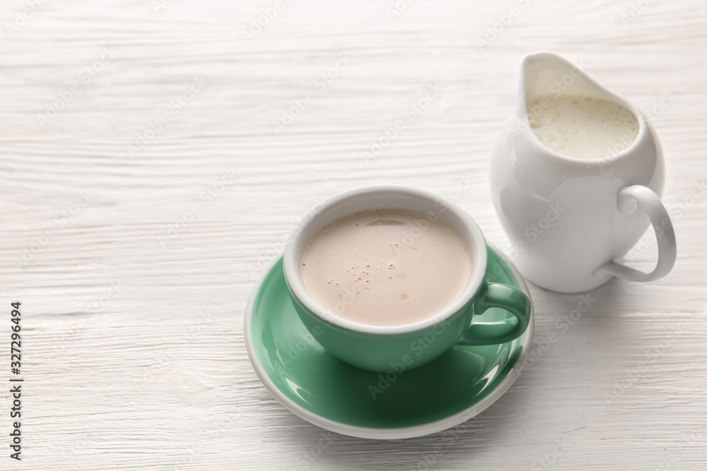 Cup of hot coffee and milk on white wooden table