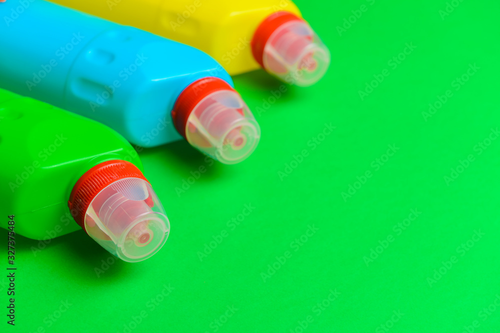 Bottles of detergents on color background