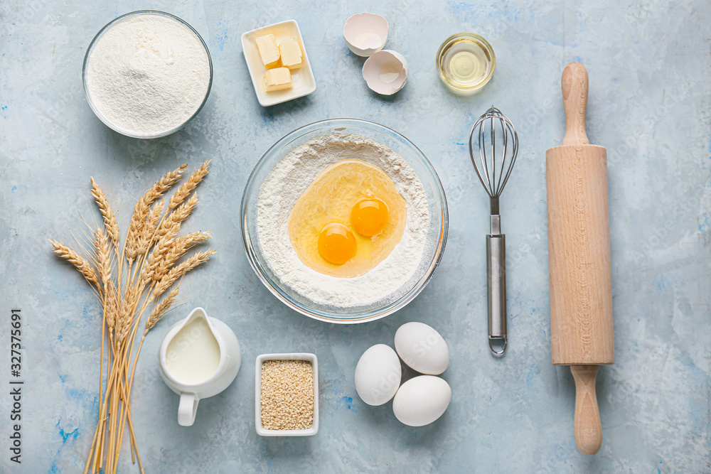 Ingredients for preparing bakery and utensils on color background