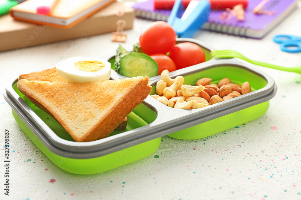 School lunch box with tasty food on table