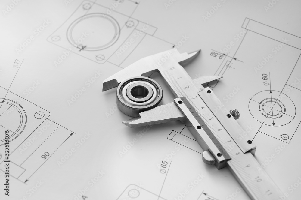 Bearing with vernier caliper and drawings on table of engineer