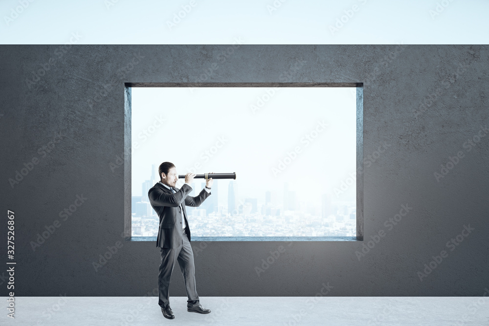 Businessman holding telescope in empty interior