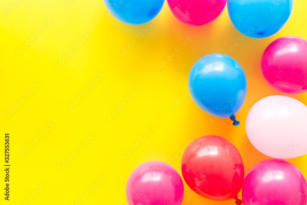 Colorful balloons frame on yellow background top-down frame copy space