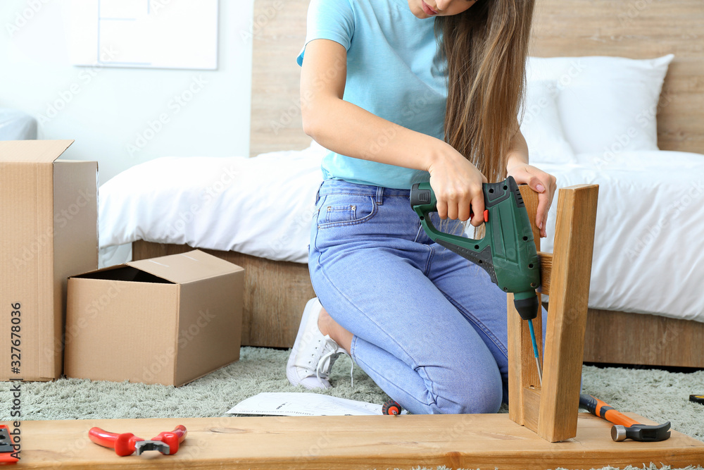 年轻女子在家组装家具