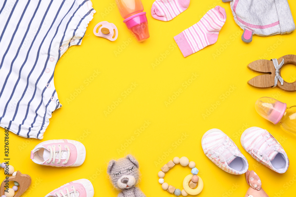 Frame made of baby clothes and accessories on color background