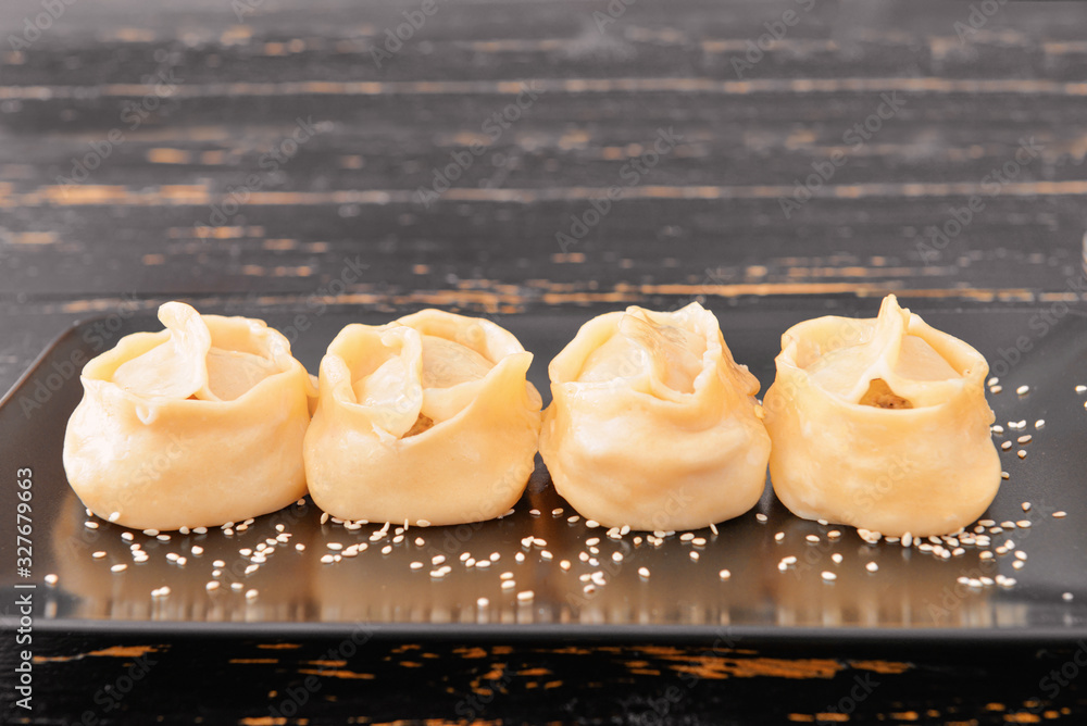 Plate with oriental dumplings on table, closeup